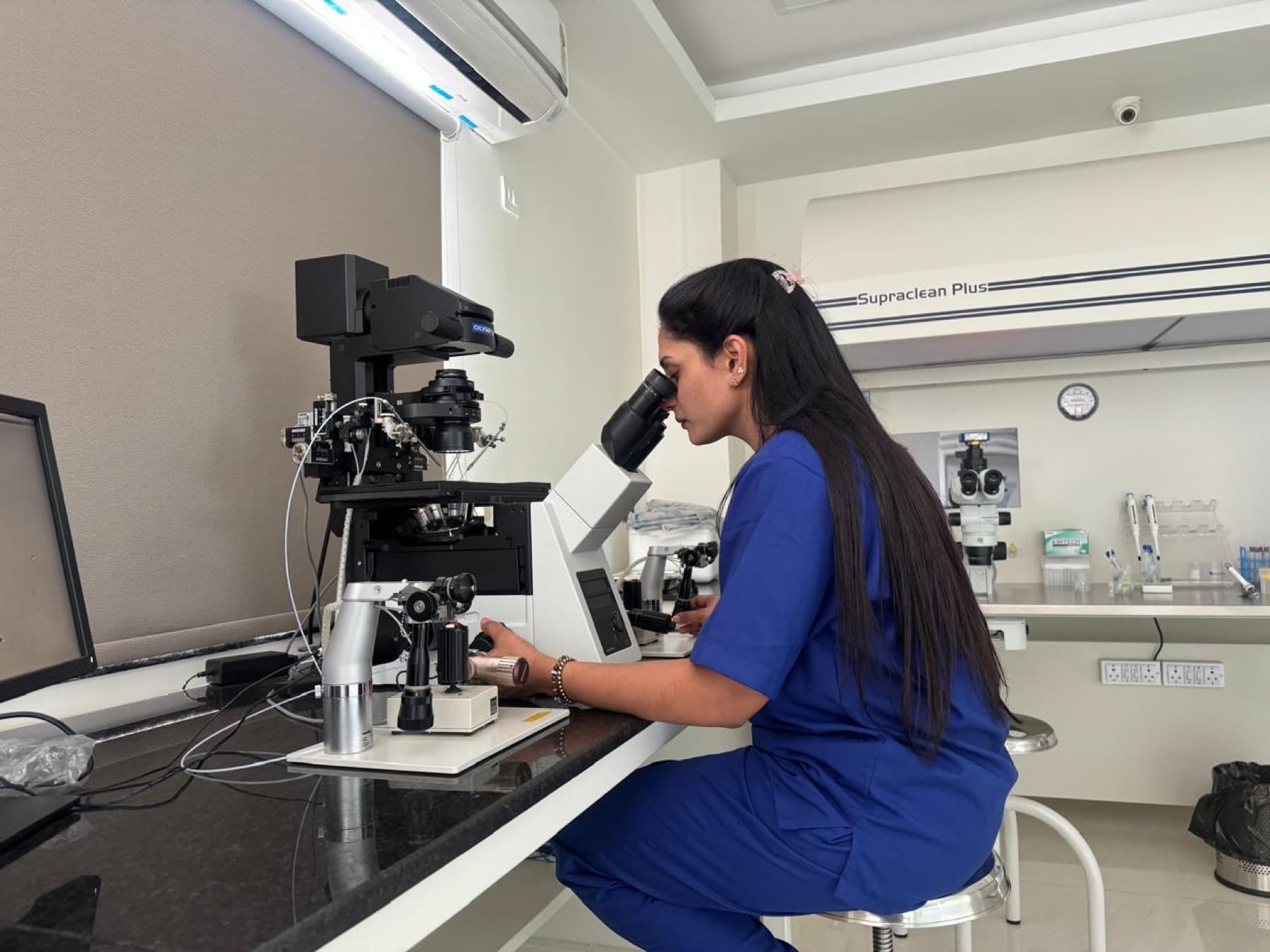 Dr. Dedeepya working with a microscope in the embryology laboratory